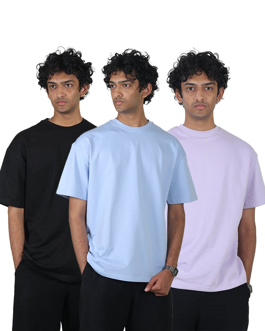 Three people wearing black, light blue, and pastel pink t-shirts on a white background