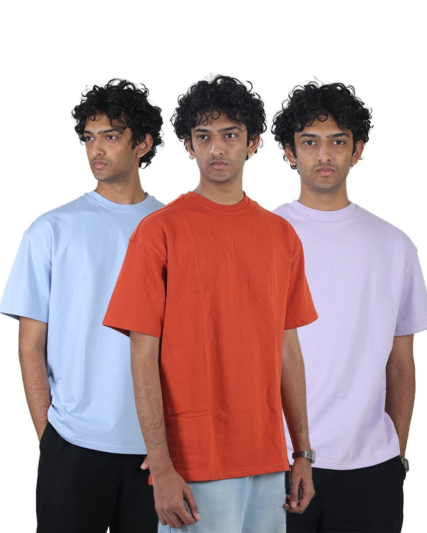 Three individuals wearing plain t-shirts in blue, orange, and white on a white background