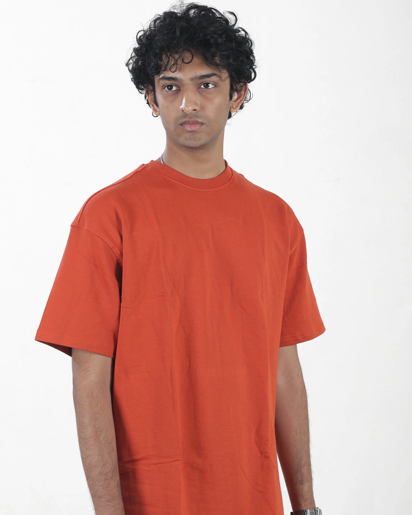 Person wearing an orange t-shirt against a white background