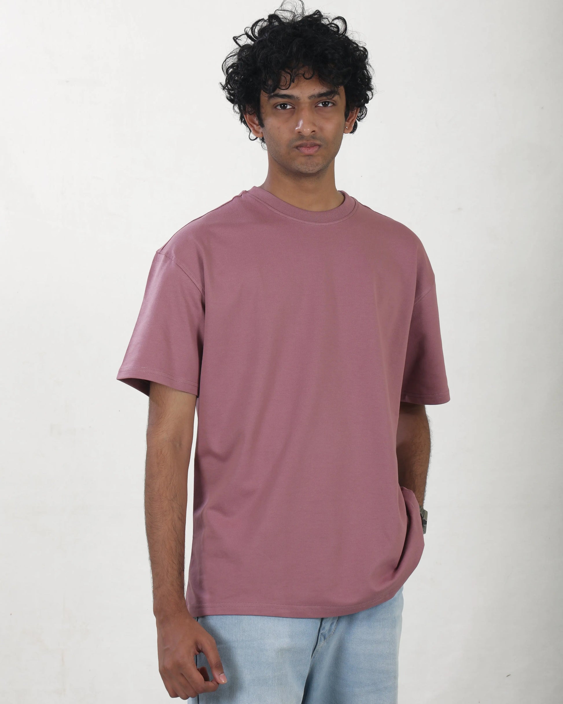 Person wearing a mauve t-shirt on a white background
