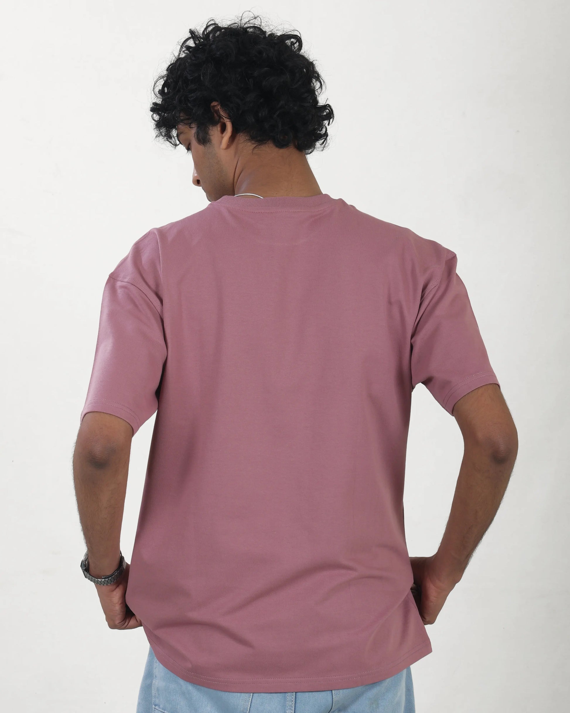 Person wearing a mauve t-shirt on a white background