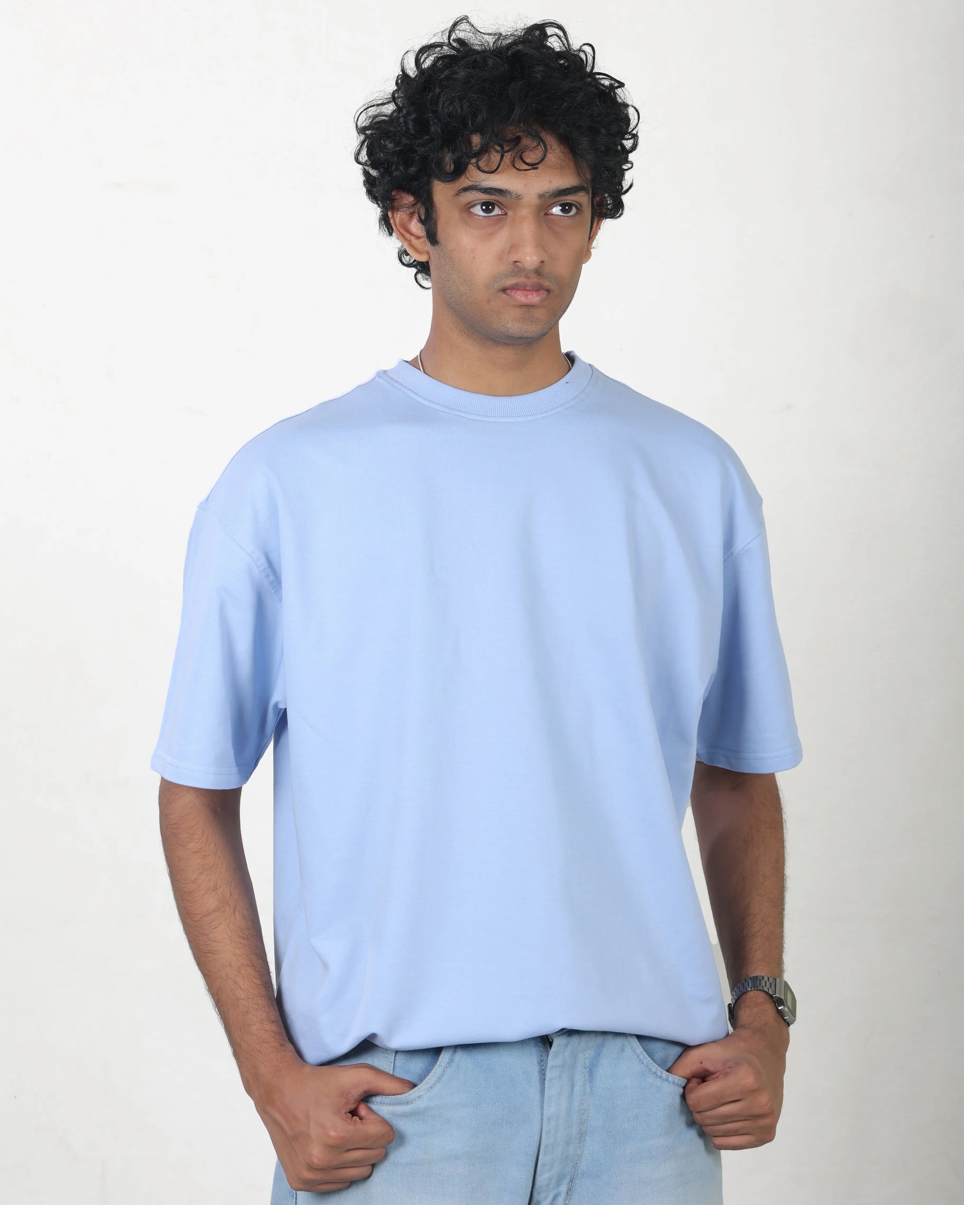 Person wearing a light blue t-shirt against a plain background
