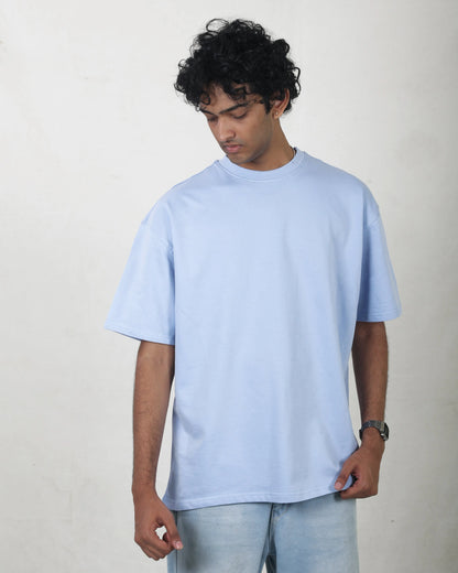 Person wearing a light blue t-shirt against a plain background