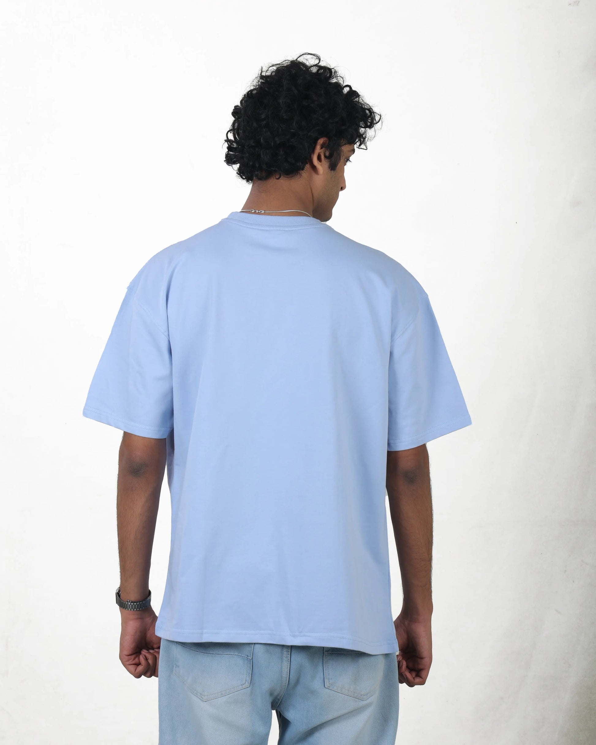 Person wearing a light blue t-shirt on a white background