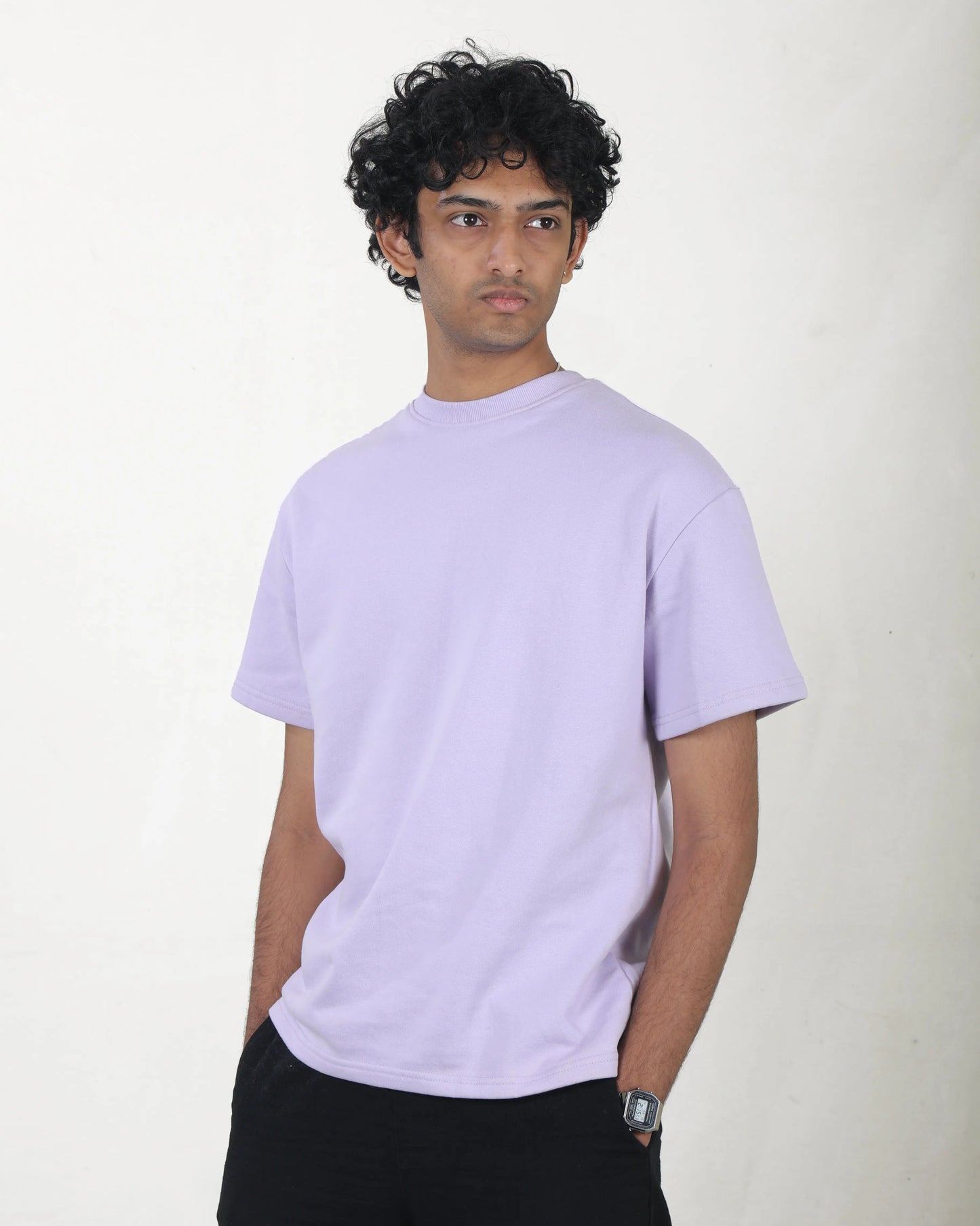 Person wearing a light purple t-shirt against a white background