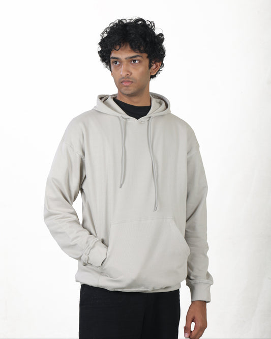 Person wearing a light gray hoodie on a white background