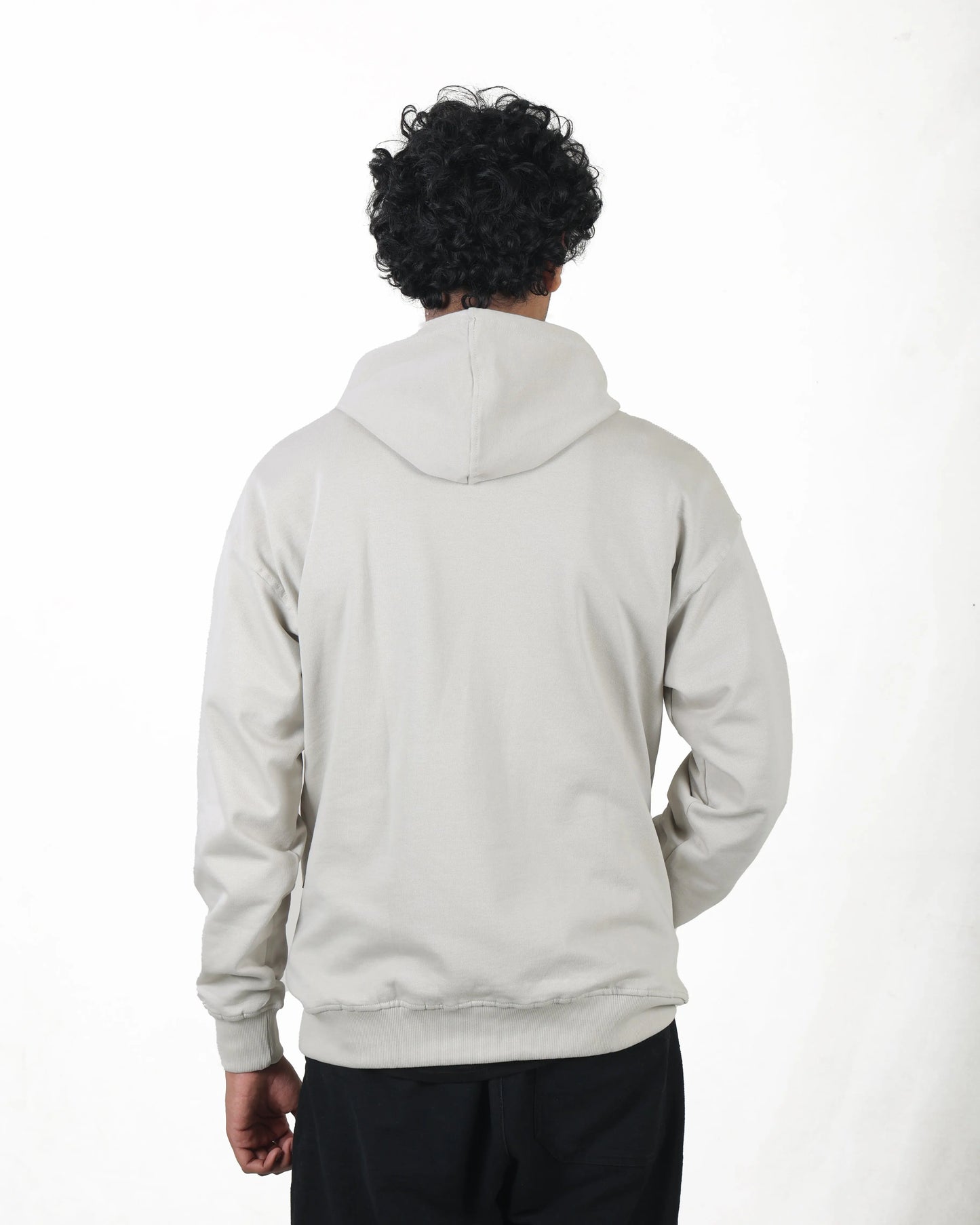 Person wearing a light gray hoodie on a white background