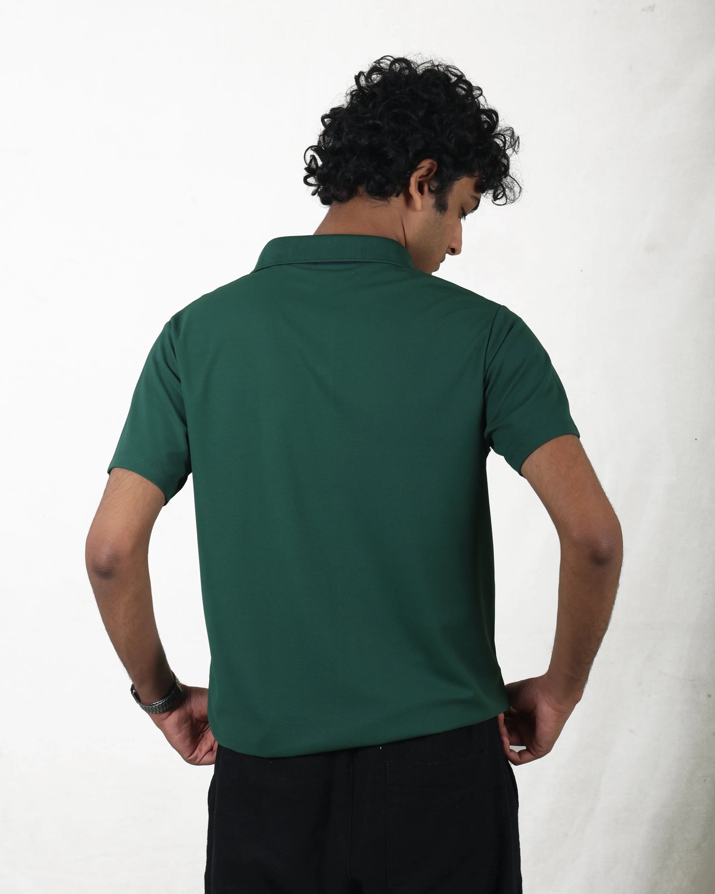 Man wearing a green polo shirt against a white background
