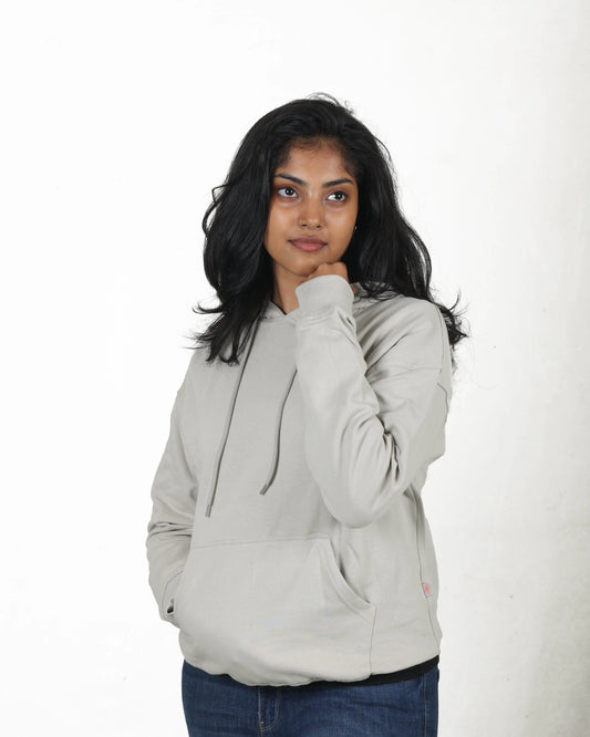 Person wearing a light gray hoodie on a white background