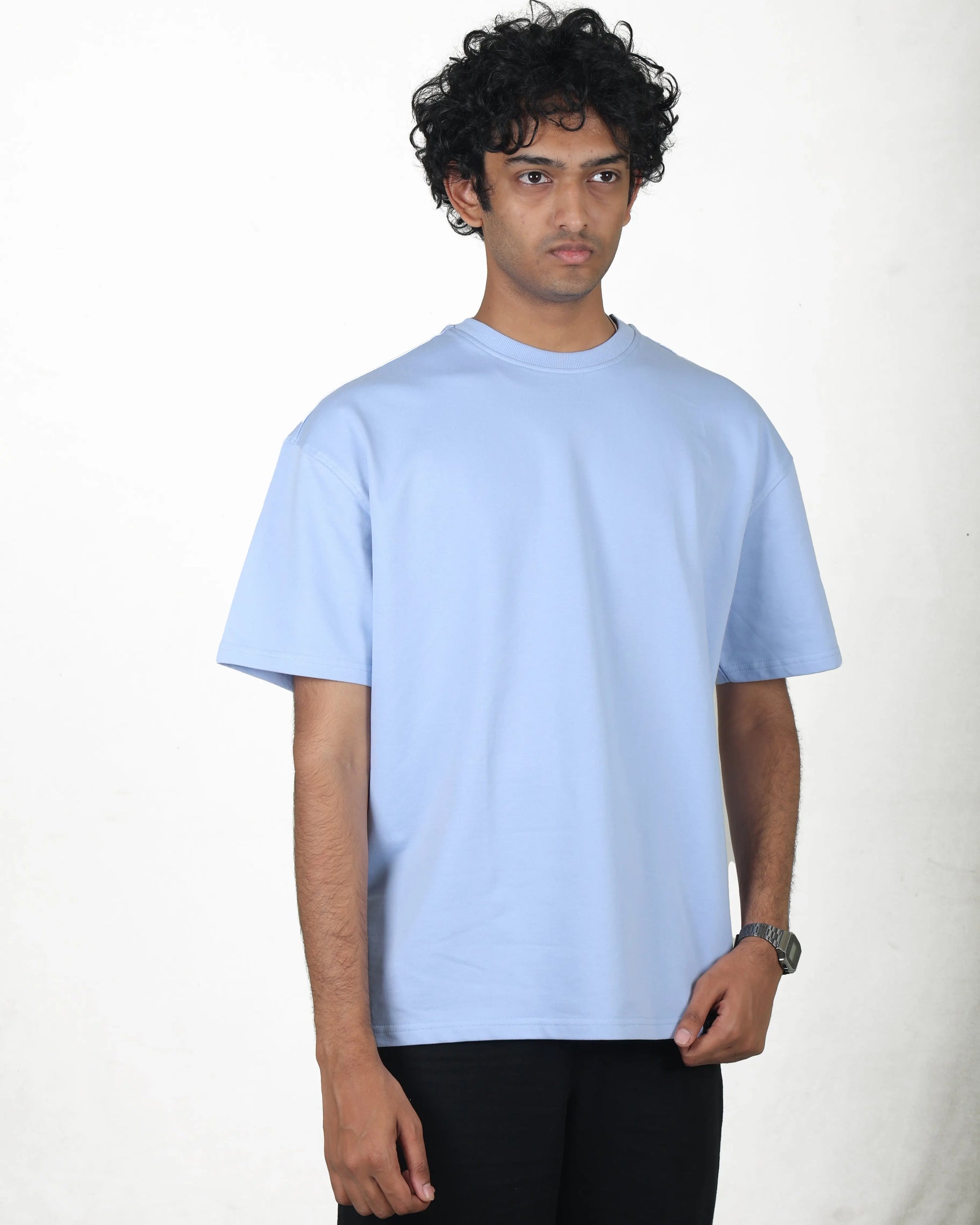 Person wearing a light blue t-shirt on a white background