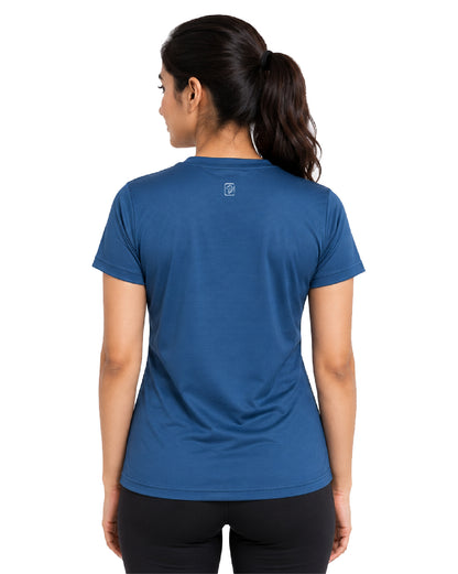 A woman viewed from the back wearing a short-sleeve athletic t-shirt in a medium blue color, paired with black leggings, against a plain white background.