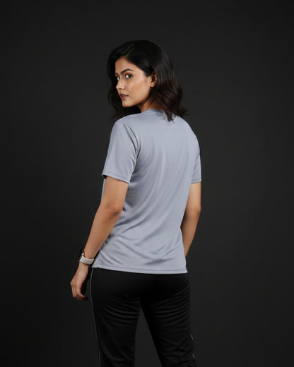 Woman wearing a light gray t-shirt on a black background