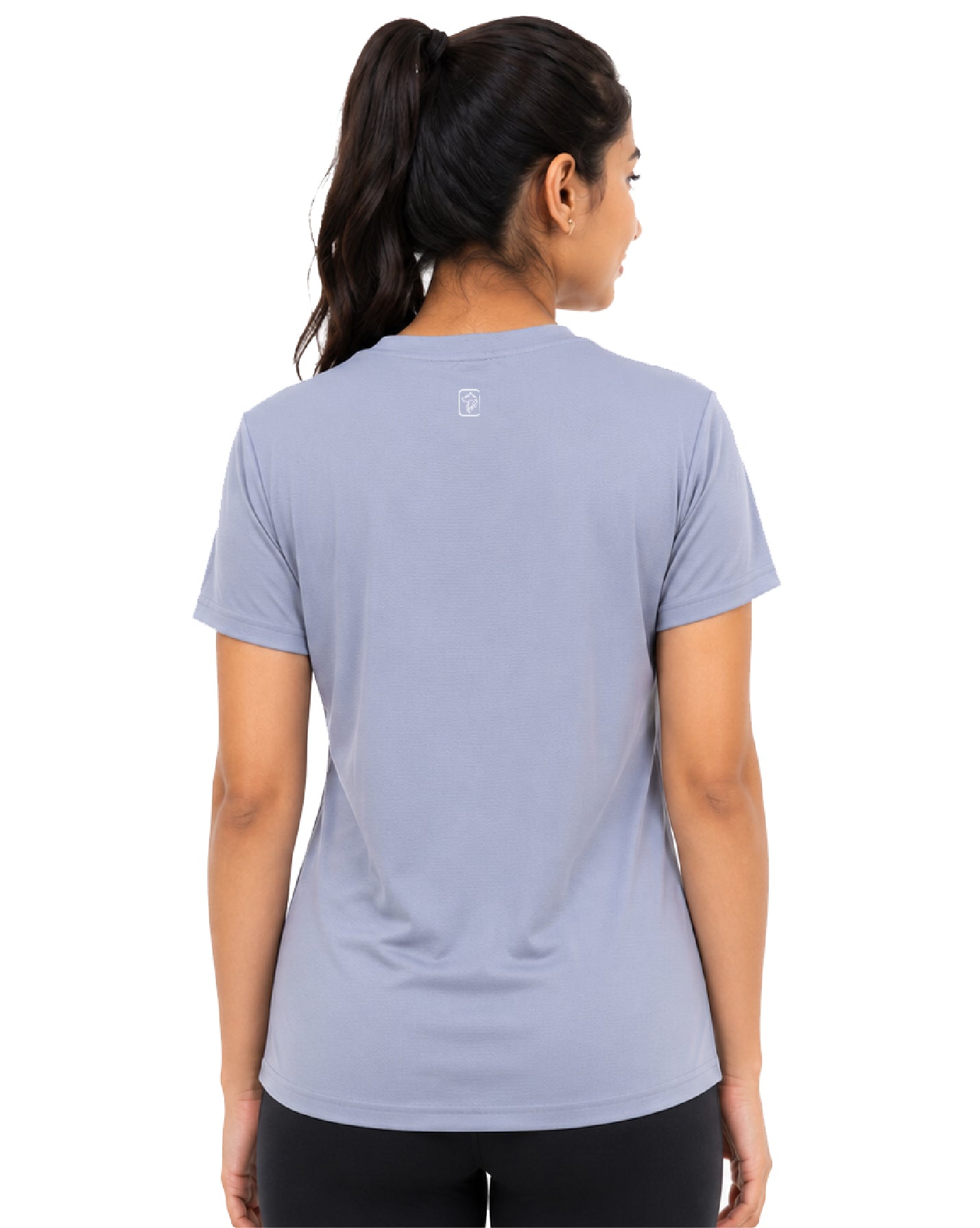 A woman shown from the back wearing a light periwinkle blue short-sleeve athletic t-shirt with a small white logo on the upper back, paired with black leggings, against a plain white background.