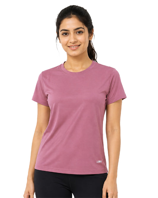 A woman wearing a short-sleeve crewneck athletic t-shirt in dusty rose pink, paired with black leggings, against a plain white background.